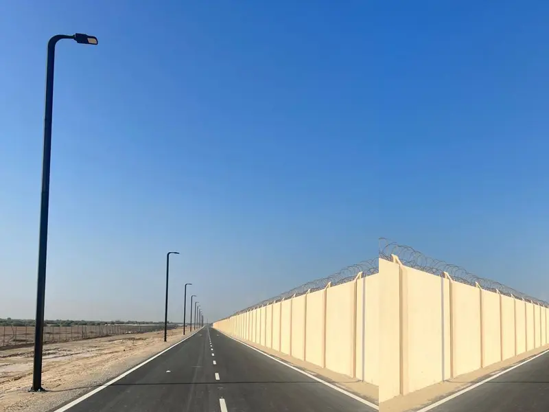 Street lighting installation and electrical infrastructure works along roadway by Osool AlRoyah General Contracting in the UAE